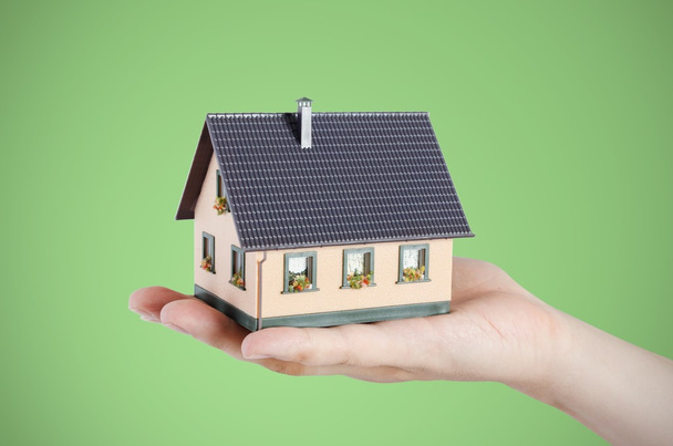 Mão segurando casa em miniatura. Conceito de financiamento doméstico
 - Foto, Imagem