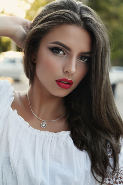 gorgeous woman with long dark hair and bright makeup   - 写真・画像