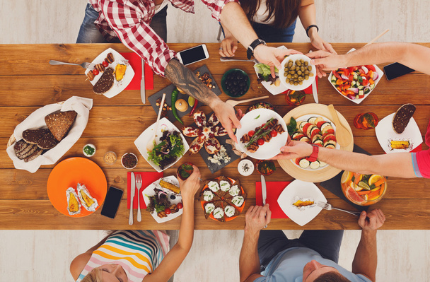 人々 はお祝いテーブルのディナー パーティーで健康的な食事を食べる - 写真・画像