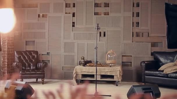 Vista do palco com microfone estúdio, mesa com saxofone. Cadeiras. Luzes
 - Filmagem, Vídeo