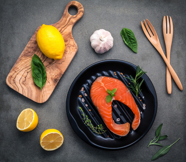 Filé de salmão cru no prato preto com ingredientes azeite
  - Foto, Imagem
