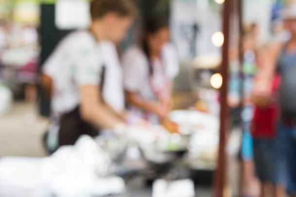 chef is cooking on the street food event. Blurred photo - Photo, Image