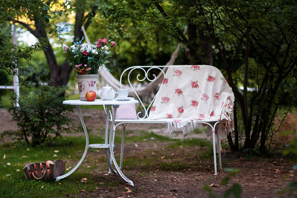 Bílý Porcelánový set na čaj nebo kávu na stůl v zahradě nad rozostření pozadí zelené přírody. Letní venkovní strana nastavení. - Fotografie, Obrázek