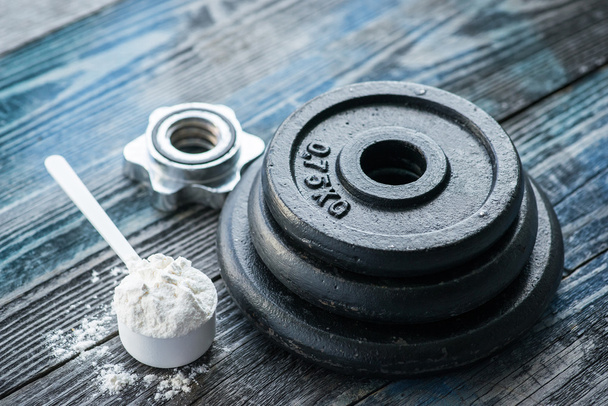 Classic dumbbell with protein powder on rustic wooden table - Photo, Image
