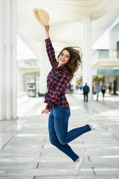 Tyttö, jolla on kauniit siniset silmät hyppäämällä kaupunkien taustalla
 - Valokuva, kuva