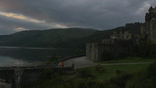 Замок Donan Eilean в сутінках з людьми - Кадри, відео