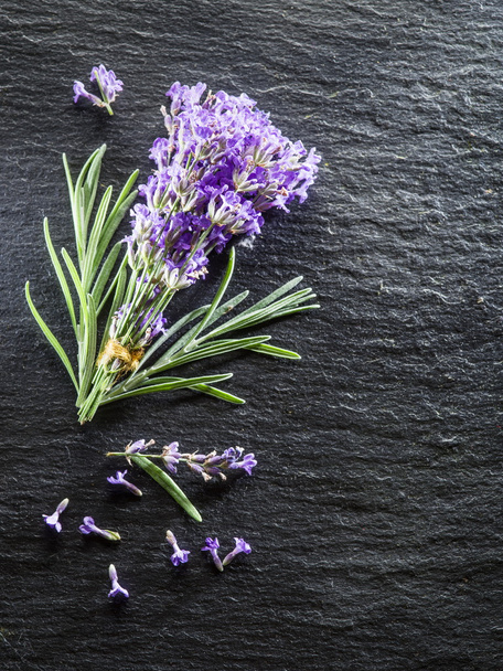 Stelletje lavandula of lavendel bloemen op grafiet bord. - Foto, afbeelding