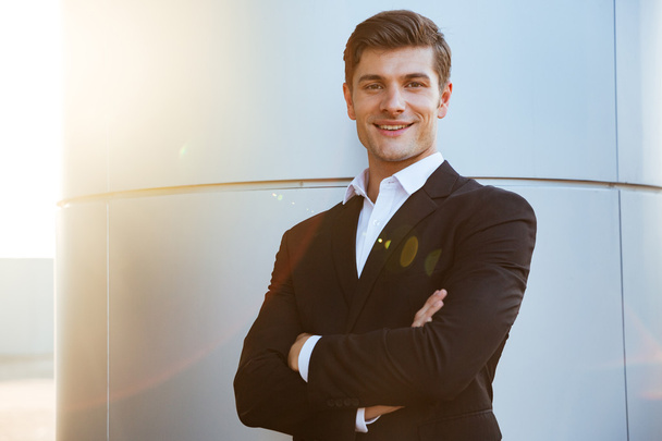 Confident successful young businessman standing with arms crossed - Foto, immagini