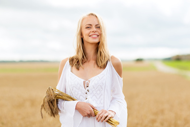 happy young woman with spikelets on cereal field - Zdjęcie, obraz