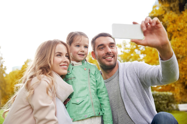 happy family taking selfie by smartphone outdoors - Fotoğraf, Görsel