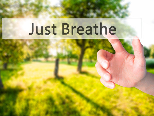 Just Breathe - Hand pressing a button on blurred background conc - Photo, Image