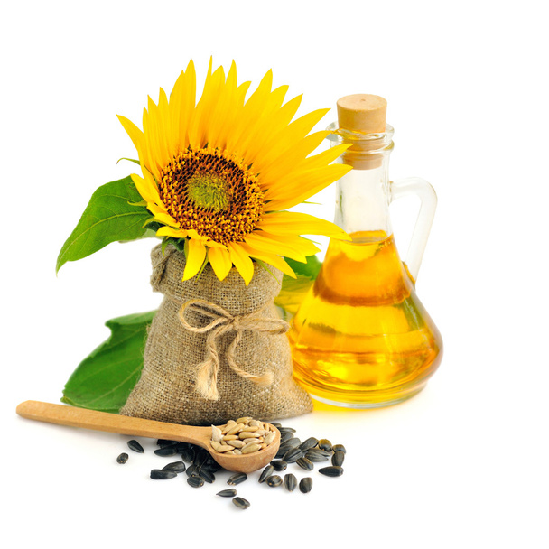 Puinen lusikka auringonkukansiemeniä taustalla pieni pussi kukka ja pullo öljyä
 - Valokuva, kuva
