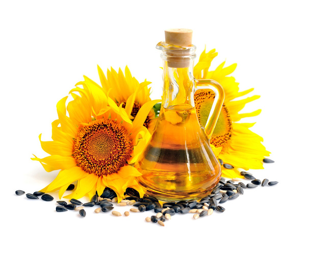 Sonnenblumenöl mit Blüten und Samen auf weißem Hintergrund - Foto, Bild