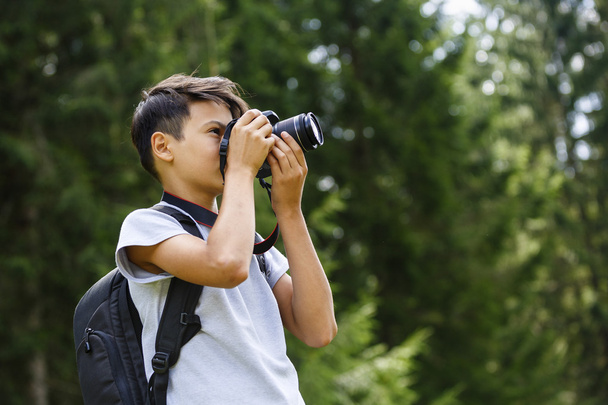 jonge jongen neemt foto's in de natuur - Foto, afbeelding