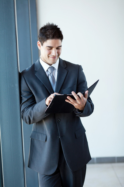 Young businessman using tablet computer in office - Foto, afbeelding