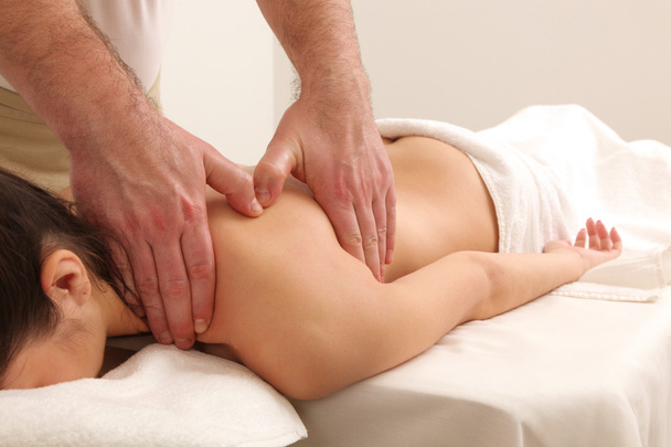 Masseur faisant massage sur le corps de la femme dans le salon de spa. - Photo, image