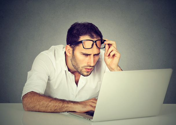 man with glasses having eyesight problems confused with laptop - Zdjęcie, obraz