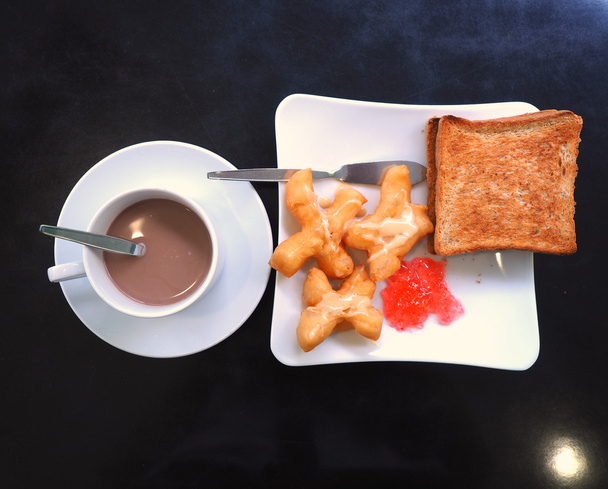 Breakfast with hot cocoa; deep-fried dough stick or Patongko with Sweetened condensed milk and toast with strawberry jam  - Photo, Image