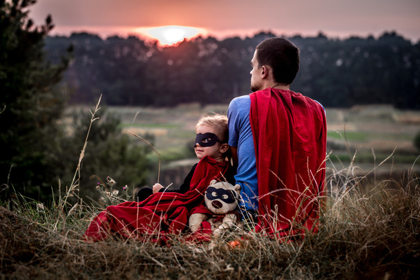 お父さん、幸せな愛情のある家族のスーパー ヒーローに身を包んだ少女 - 写真・画像