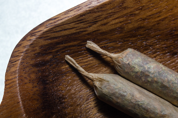 stock de joints de marijuana faits à la main sur plateau en bois
 - Photo, image