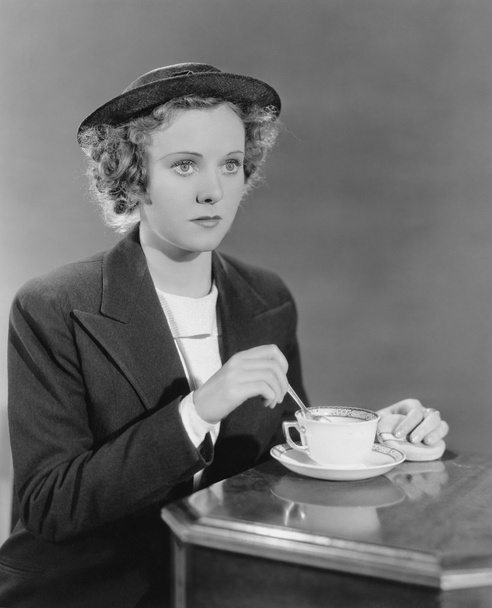 Portrait of woman stirring beverage - Foto, imagen