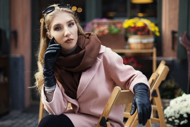 Retrato de hermosa mujer joven con estilo sentado en la cafetería de la calle. Modelo mirando a la cámara. De cerca. Estilo de vida. Moda femenina
 - Foto, Imagen