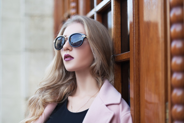 Güneş gözlüğü ile güzel genç moda kadın kenara bakıyor. Kadın modası. Yakın çekim portre - Fotoğraf, Görsel