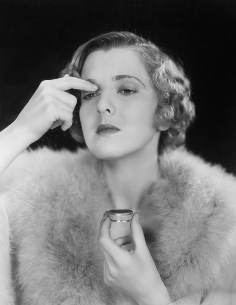Portrait of woman applying makeup - Foto, afbeelding