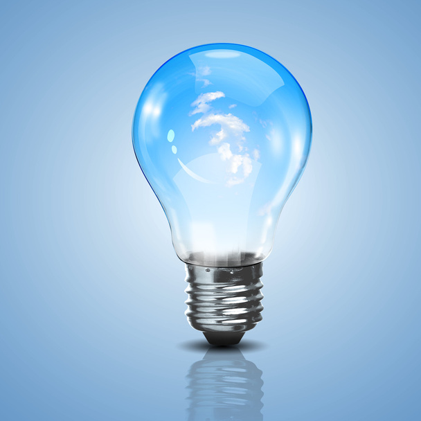 Electric light bulb and blue sky inside it - Foto, afbeelding