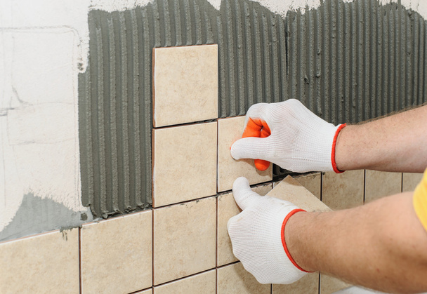 Worker  putting  tiles on the wall in the kitchen. - Photo, Image