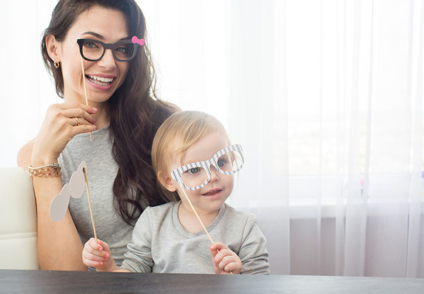 Mother and her daughter girl with a paper accessories. - Foto, Bild