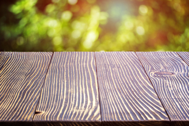 Wooden deck table over beautiful bokeh  - Photo, Image