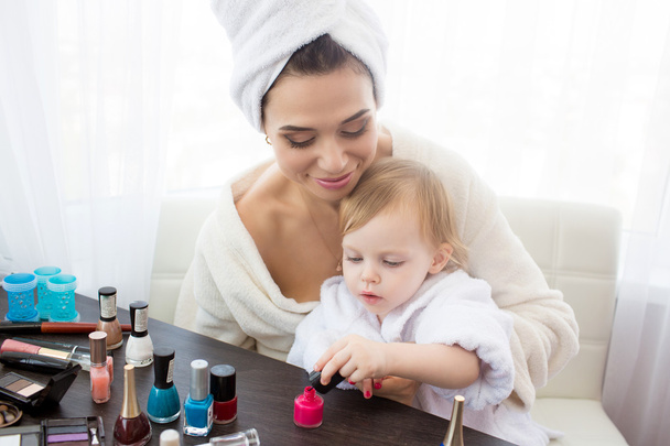 Mother and daughter are doing hair, manicures, makeup, having fun. - Foto, afbeelding