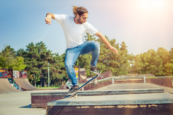 Skater jumping in skateboard park - 写真・画像