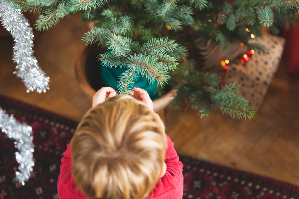 criança decorando a árvore de Natal
 - Foto, Imagem