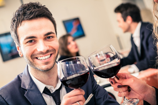 Handsome smiling man drinking wine - Фото, изображение