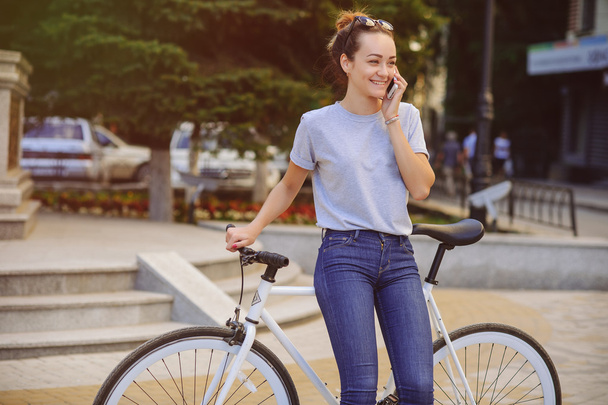chica con bicicleta hablando por teléfono
 - Foto, Imagen