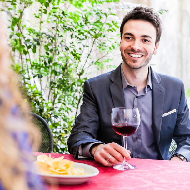 Handsome young man with glass of wine - Фото, изображение
