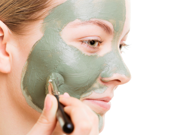 Donna che applica con pennello argilla fango maschera il viso - Foto, immagini