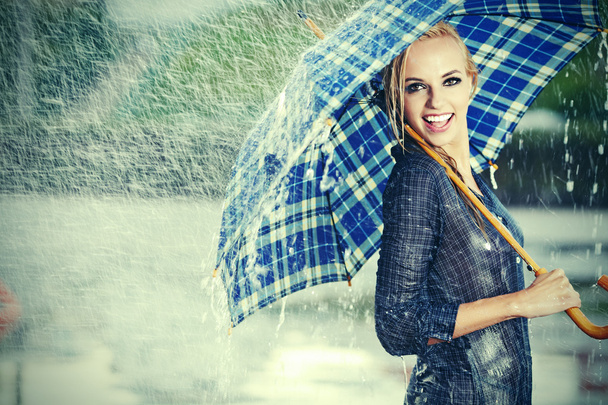 Sexy girl under umbrella watching the rain - Фото, изображение