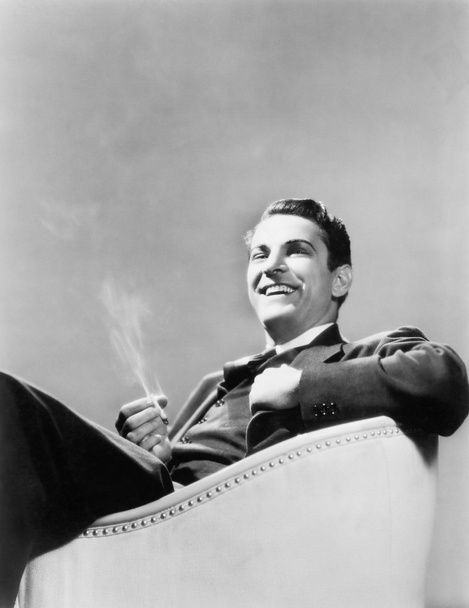 Az ember ül egy kar szék dohányzás - Fotó, kép