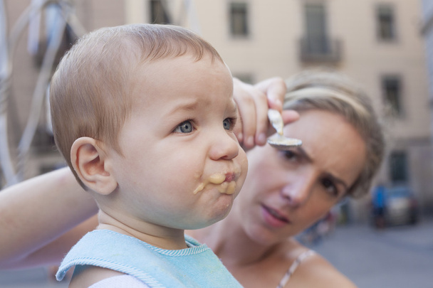 Mãe tentando alimentar seu menino
  - Foto, Imagem