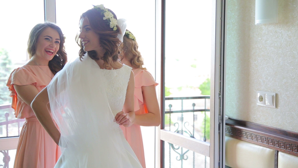 Divertidos mejores amigos ayudan a usar vestido de novia en el balcón
 - Imágenes, Vídeo