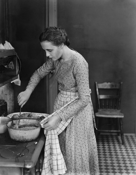προφίλ μιας νεαρής γυναίκας μαγείρεμα των τροφίμων στην κουζίνα - Φωτογραφία, εικόνα