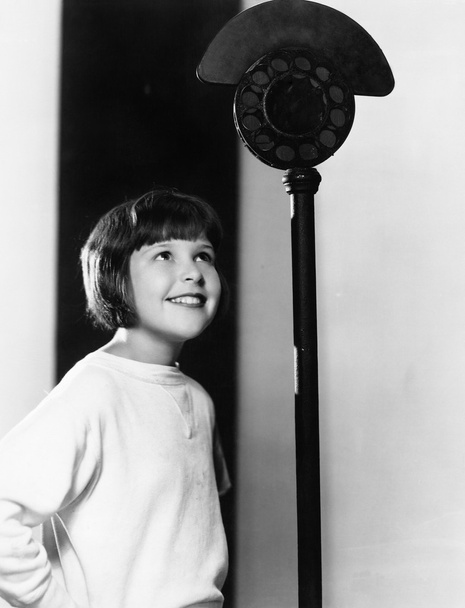 Profile of a young girl looking at a microphone and smiling - Photo, Image