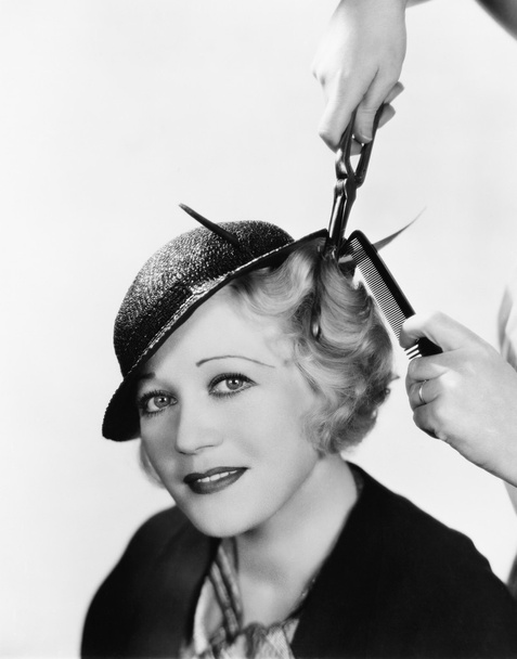 Portrait of a young woman getting her hair curled with an iron - Fotoğraf, Görsel