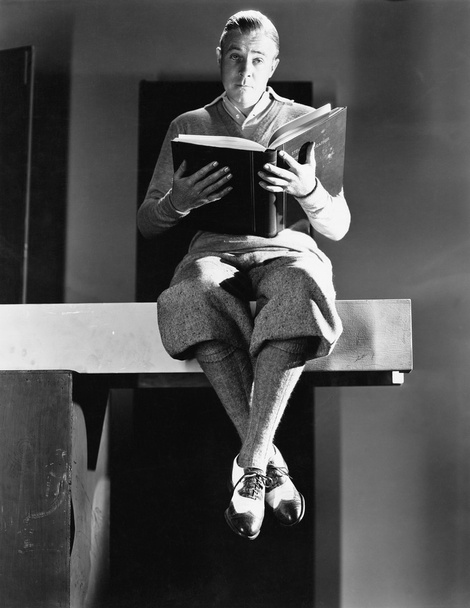 Egy férfi ül egy fa deszkát, és aki olyan könyvet portréja - Fotó, kép