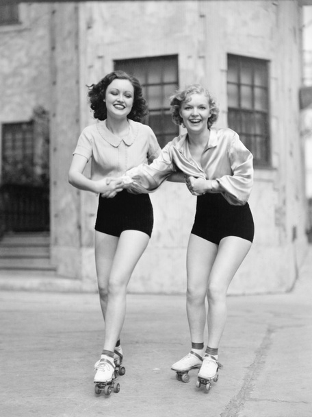 Görgő penge, korcsolya, úton, és mosolyogva két fiatal nő portréja - Fotó, kép