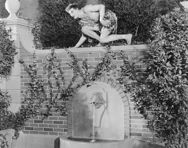 Perfil de un joven agachado en una pared
 - Foto, Imagen
