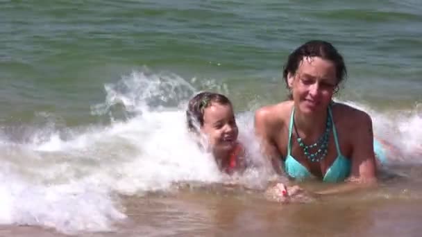 Mother with little girl on splashing beach - 映像、動画